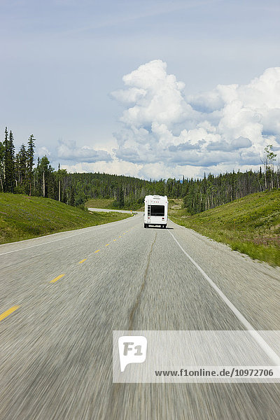 A recreational vehicle driving along the Alaska Highway alongside the Liard River  British Columbia  Canada  Summer