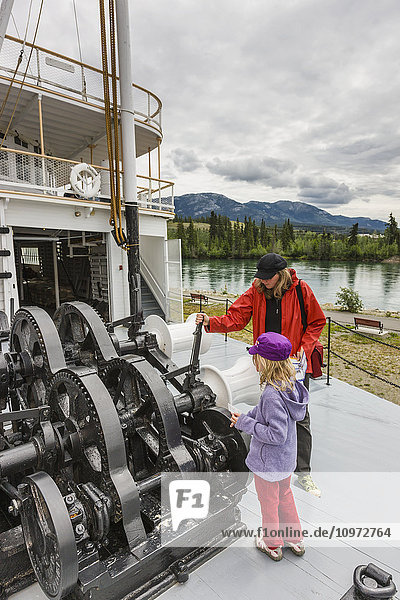 Mother and daughter looking at the engine of the SS Klondike  Whitehorse  Yukon Territory  Canada  Summer