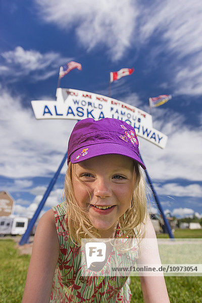 A Young Girl under the World Famous Alaska Highway Sign  Dawson Creek  British Columbia  Canada  Summer