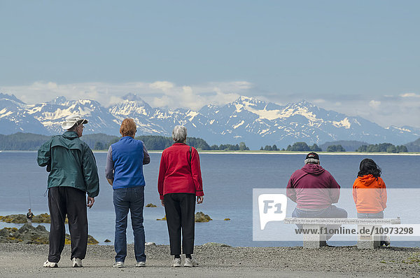 Tourists looking across Lynn Canal at the Chilkat Mountains at the Shrine of St. Therese near Juneau  Southeast Alaska