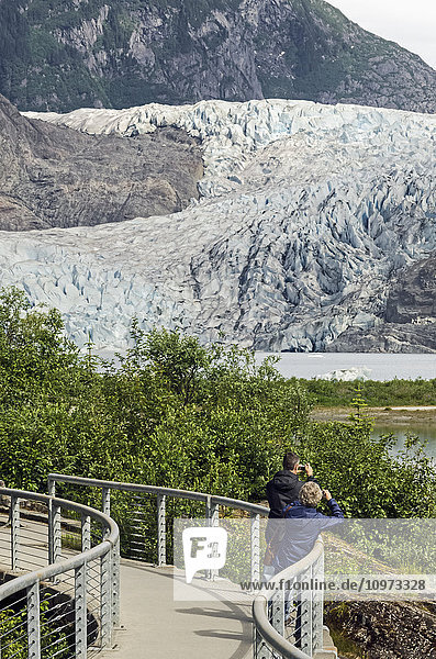 Tourists photographing Mendenhall Glacier in Tongass National Forest  Southeast Alaska  summer