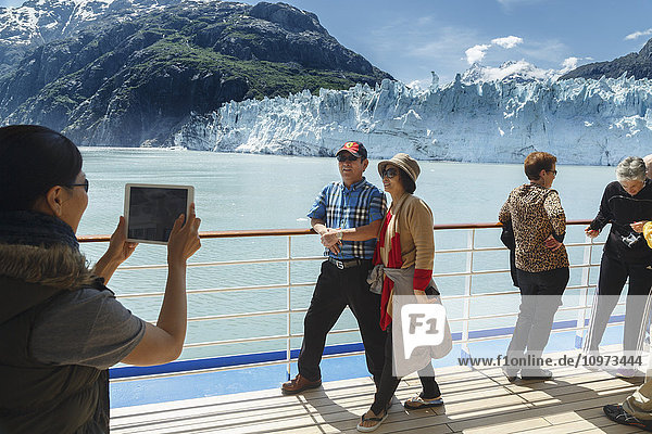 Tourists view Margerie Glacier from Coral Princess cruise ship deck in Tarr Inlet with Fairweather Mountain Range in Glacier Bay National Park  Southeast Alaska