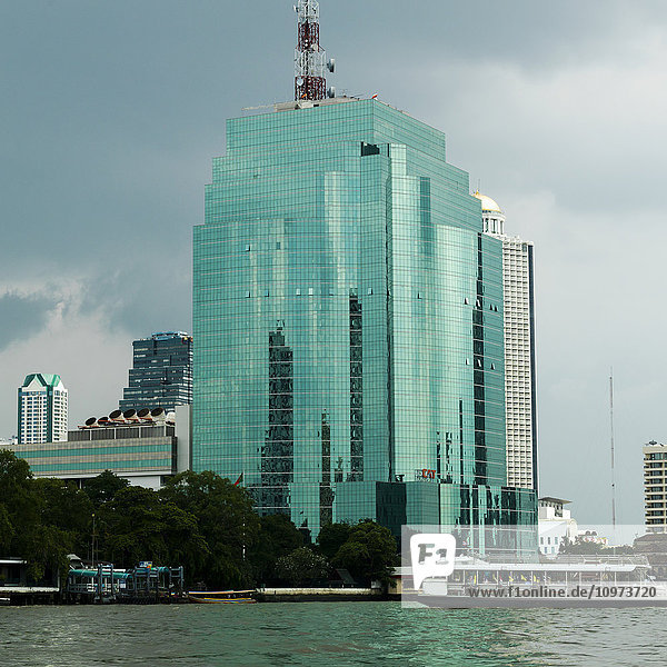 'Modern building with green glass facade along the riverfront; Bangkok  Thailand'