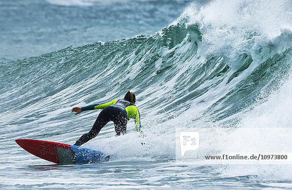 Surfer  der eine Welle erwischt; Tarifa  Cadiz  Andalusien  Spanien'.