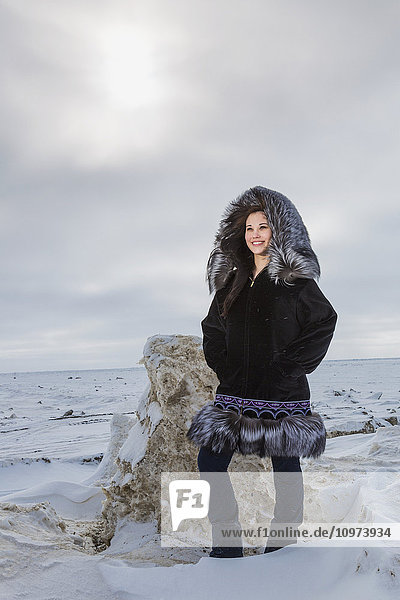 Female native youth wearing a traditional fur parka while standing on ice along the Arctic Ocean  Barrow  North Slope  Arctic Alaska  USA  Winter