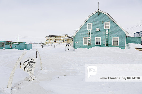 Utqiagvik Presbyterian Church with a whale bone sign in the foreground  Barrow  North Slope  Arctic Alaska  USA  Winter