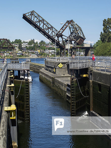 The doors of an open lock and a draw bridge raised in the background  Ballard Locks  Seattle  Washington  USA  Summer