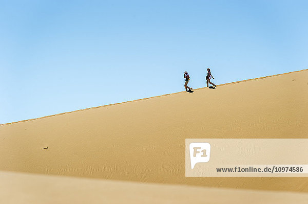 Menschen wandern durch die Wüste; Sossusvlei  Namibia'.