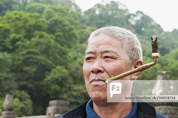 'A man smoking in Leshan Giant Buddha scenic area; Sichuan Province  China'