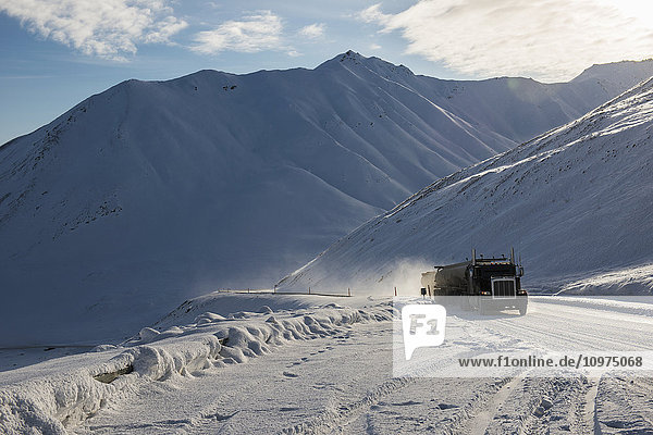 Ein kommerzieller Lkw arbeitet sich im Frühjahr auf dem Dalton Highway zum Atigun Pass hinauf  Brooks Range  Arctic Alaska