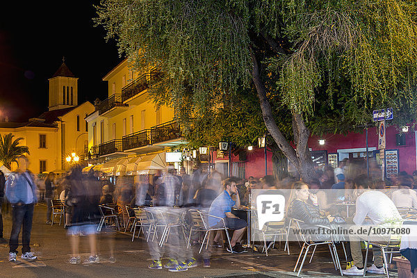 Touristen sitzen nachts an Cafétischen; San Teodoro  Sardinien  Italien'.