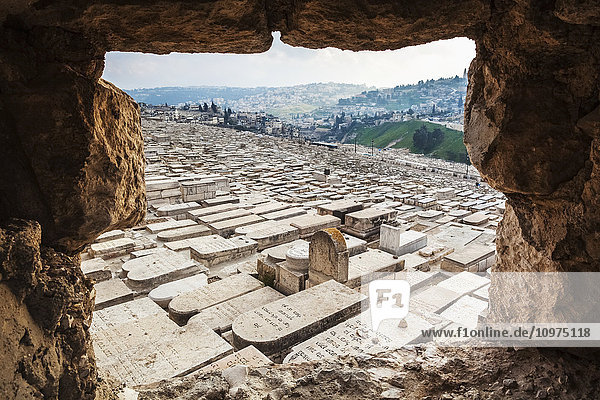 'Jewish graves viewed from a hole in the wall of a walkway that leads down the Mount of Olives; Jerusalem  Israel'