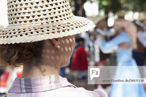 Der Hinterkopf einer Frau mit Sonnenhut  die ein tanzendes Paar beobachtet; Havanna  Kuba