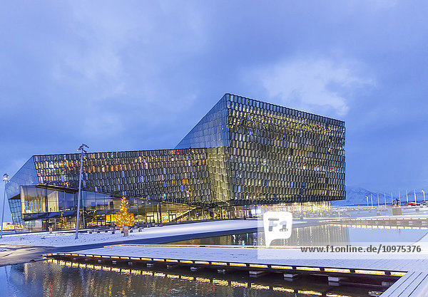Außenansicht der öffentlichen Konzerthalle Harpa  entworfen von dem dänischen Büro Henning Larsen Architects und dem isländischen Büro Batteriao Architects; die Glasfassade wurde von dem isländischen Glaskünstler Olafur Eliasson in der Dämmerung entworfen; Reykjavik  Island'