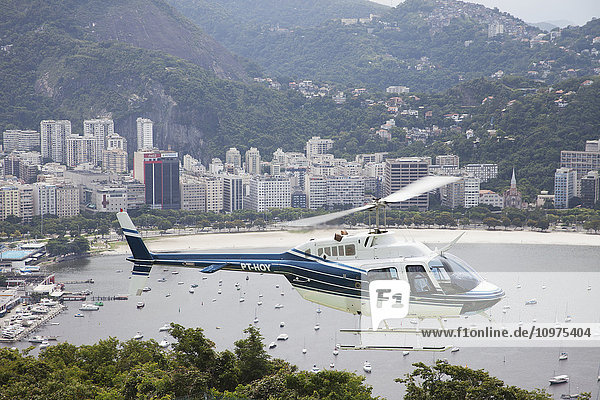 Sightseeing-Hubschrauber vom Zuckerhut aus gesehen  mit Blick auf die Bucht von Botafogo; Rio de Janeiro  Brasilien'.