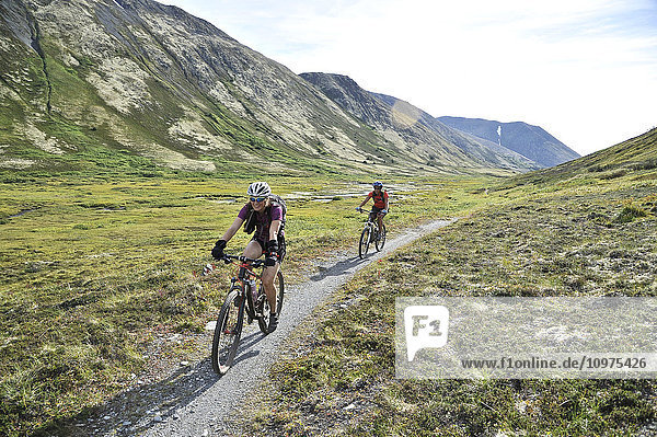 Women ride full suspension mountain bikes on the Resurrection Pass Trail in the Chugach National Forest  Kenai Peninsula  Southcentral Alaska