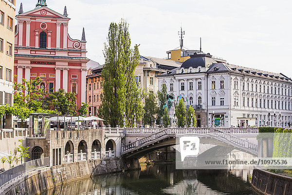 'The Slovenian capital city of Ljubljana with a footbridge over a tranquil canal; Ljubljana Slovenia'