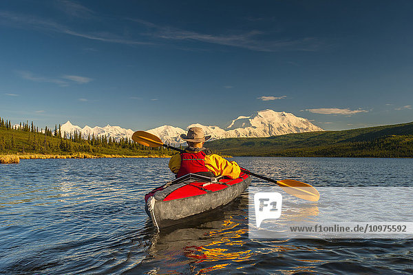 Mann beim Kajakfahren auf dem Wonder Lake mit dem Denali im Hintergrund  Inneres Alaska  Sommer