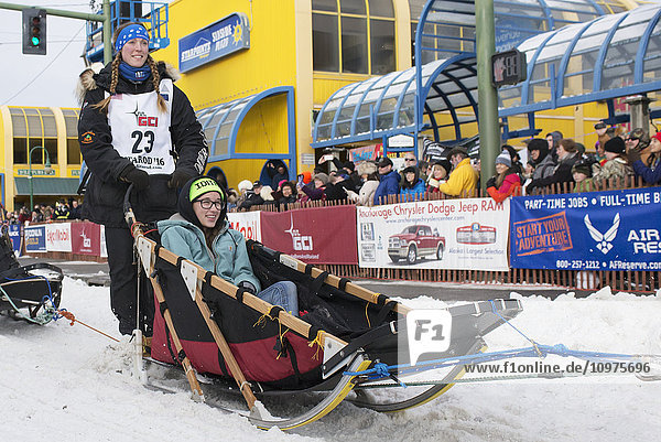Anna Berington and team leave the ceremonial start line with an Iditarider during the 2016 Iditarod
