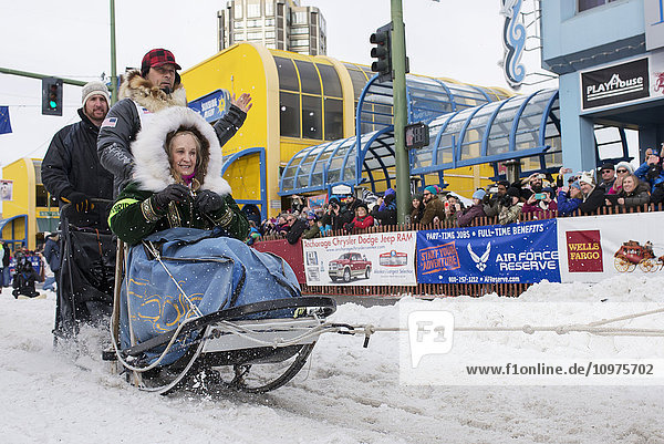 Martin Buser and team leave the ceremonial start line with an Iditarider during the 2016 Iditarod