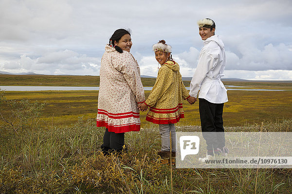 Ein junger Yupik-Inupiag-Eskimo und ein Yupik-Eskimo-Mädchen stehen mit Blick auf die sommerliche Tundra und das Land außerhalb von Nome  Alaska