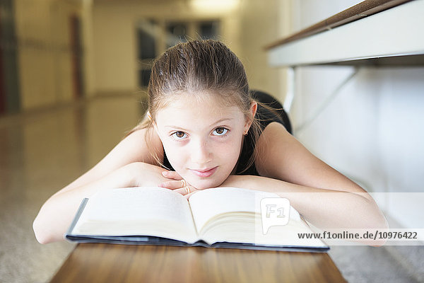 Junges Mädchen liegt auf einer Bank und liest ein Buch; Toronto  Ontario  Kanada'.