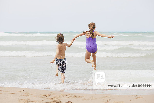 'Boy and girl running on beach; Grand Bend  Ontario  Canada'