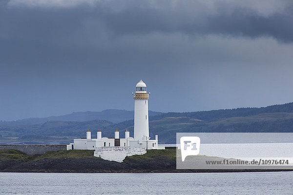 Weißer Leuchtturm unter Gewitterwolken an der Küste; Schottland'.