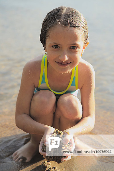 'Young girl at the beach playing in the sand; Ontario  Canada'