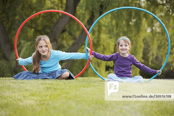 Junge Mädchen spielen mit Hula-Hoop-Reifen in einem Park; Toronto  Ontario  Kanada'.