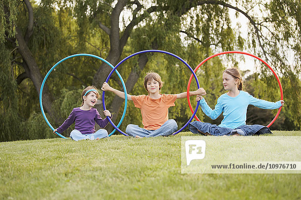 Kinder spielen mit Hula-Hoop-Reifen in einem Park; Toronto  Ontario  Kanada'.