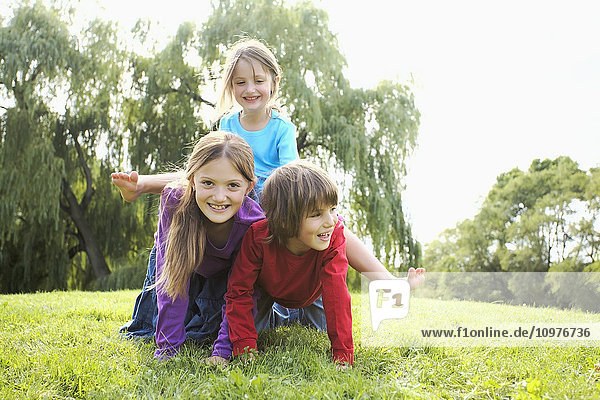 Kinder bauen in einem Park eine menschliche Pyramide; Toronto  Ontario  Kanada'.