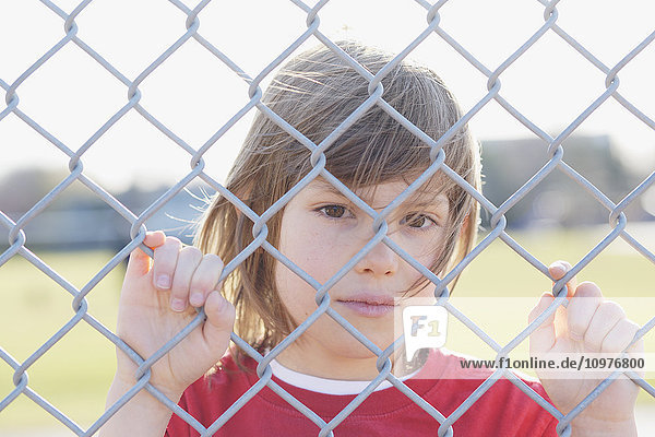 Junger Junge hinter einem Zaun; Toronto  Ontario  Kanada'.