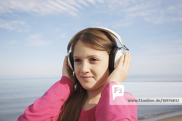 Mädchen mit Kopfhörern am Strand; Toronto  Ontario  Kanada'.
