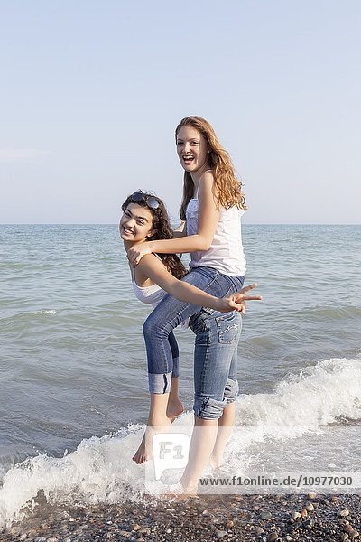 Zwei Mädchen spielen Huckepack am Strand; Toronto  Ontario  Kanada'.