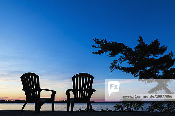 Silhouette von Muskoka Stühlen und Balsam Lake bei Sonnenaufgang; Ontario  Kanada'.