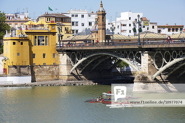 Kajakfahrer unter der Triana-Brücke auf dem Fluss Guadalquivir; Sevilla  Spanien'.