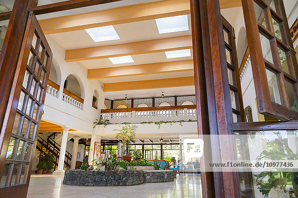 Ein offener  einladender Eingang in die Lobby eines Resorts in der Karibik mit traditioneller Architektur  Fensterläden und offenen  großen Türen  die Touristen ins Innere dieses Resorts führen; Varadero  Kuba.
