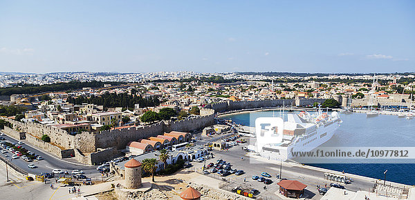 Panoramablick auf die Skyline des Hafens von Rhodos  Griechenland  mit einem kleinen Kreuzfahrtschiff und Blick auf die historische Stadtmauer in der Ägäis; Rhodos  Griechenland'.