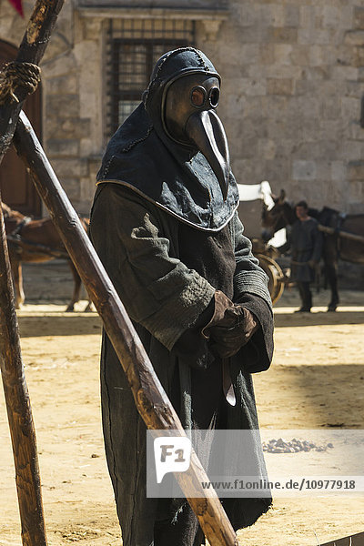 Mann in mittelalterlicher Tracht mit einer Maske  die sein Gesicht verdeckt; Montepulciano  Toskana  Italien'.