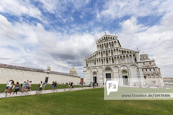 Touristen spazieren über die Piazza Dei Miracoli und besuchen die historische Stätte und den Schiefen Turm von Pisa; Pisa  Siena  Italien'.