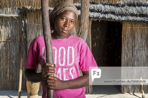 Afrikanische Frau hält einen Stößel im Dorf Sexaxa; Maun  Botswana