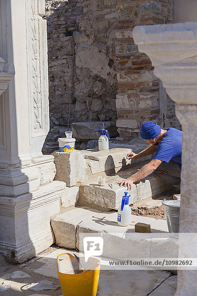 Ein männlicher Archäologe arbeitet mit feinen Werkzeugen an der heiklen Aufgabe der Restaurierung und Wiederherstellung der Ruinen von Ephesus; Ephesus  Türkei'.