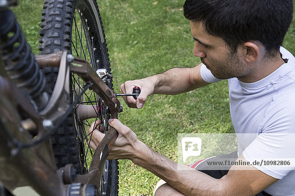 Man examining and adjusting the wheel of a mountainbike