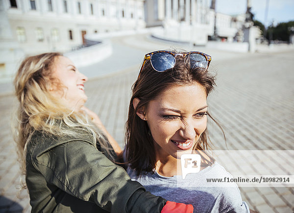 Österreich  Wien  zwei junge Frauen mit Spaß vor dem Parlamentsgebäude