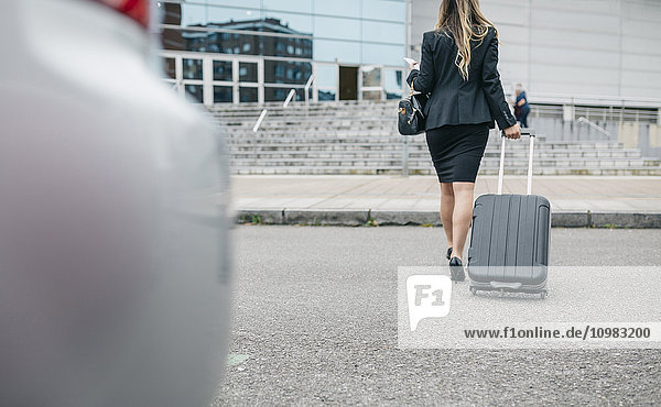 Geschäftsfrau mit Koffer unterwegs