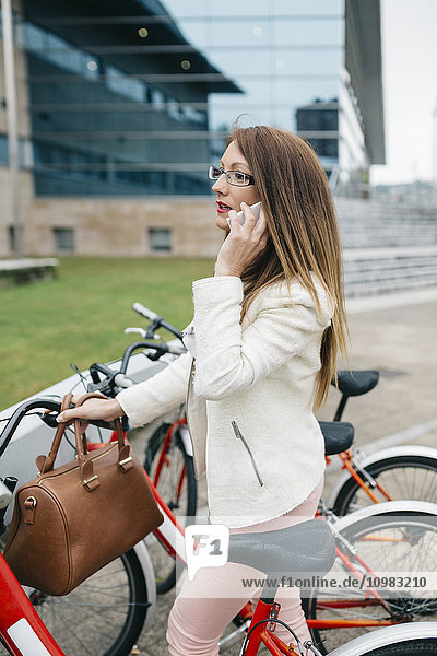 Geschäftsfrau mit Fahrrad am Handy