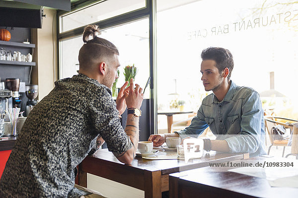 To young men socializing in a cafe