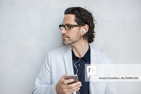 Geschäftsmann mit Smartphone und Kopfhörer