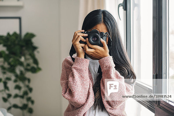 Frau fotografiert den Betrachter mit der Kamera